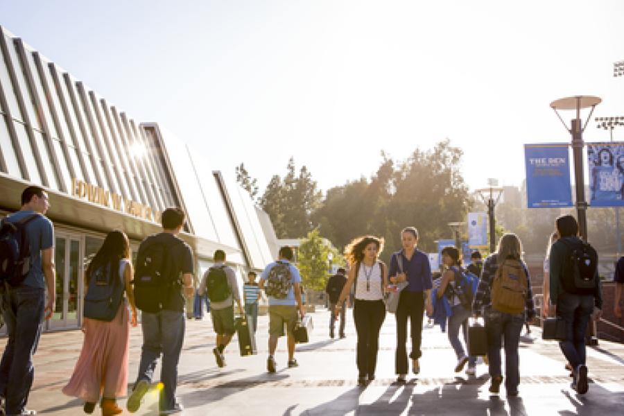 Students walking in front of the Pauley Pavilion building 