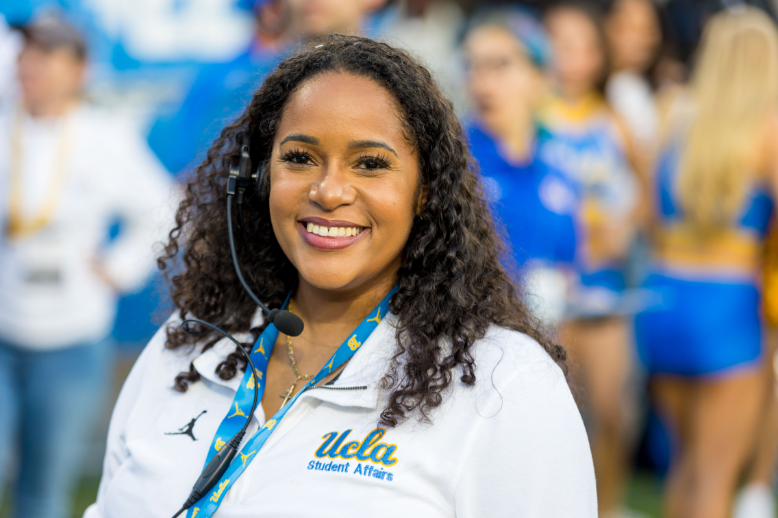 A photo of a UCLA staff member helping at a sporting event