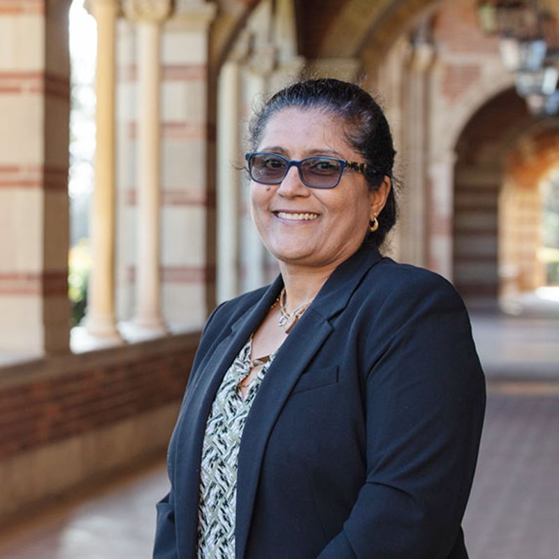 A UCLA staff member smiling in front of Royce Hall