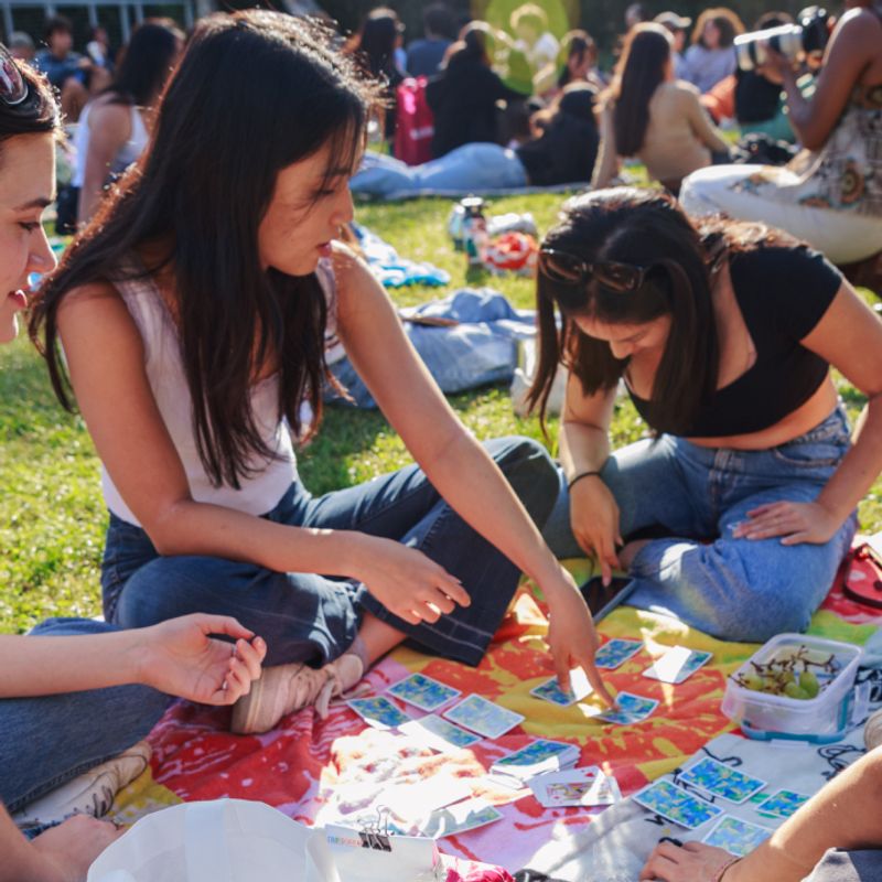 A UCLA students playing a card game on a lawn outside