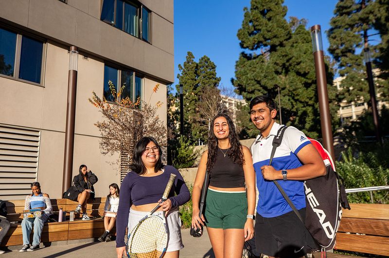 Students get ready to play tennis using facilities near their residence halls